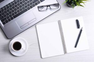 open notebook next to a laptop