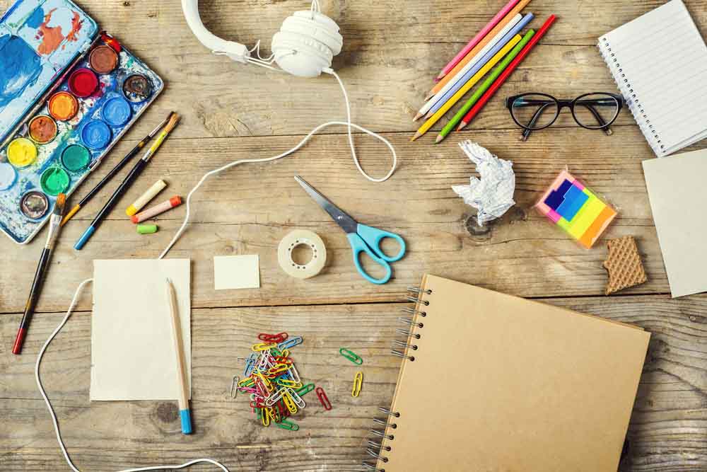 various art materials sprawled on top of a desk